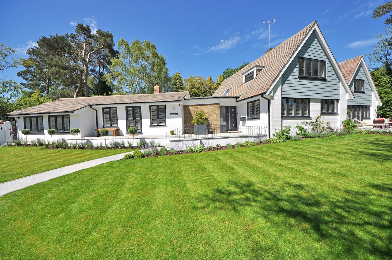 Mastering the First Impression: Your intriguing post title goes here Contemporary house exterior with large manicured lawn and beautiful garden.